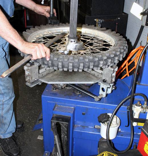 A person working on a motorcycle tire.