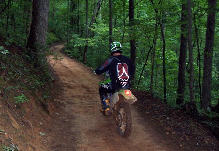 A person riding a dirt bike on top of a trail.