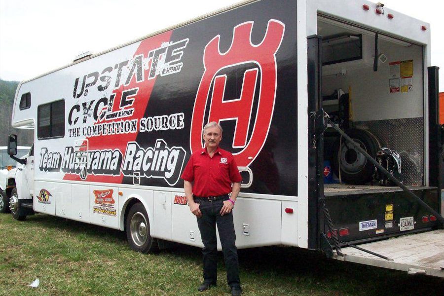 A man standing in front of a racing truck.