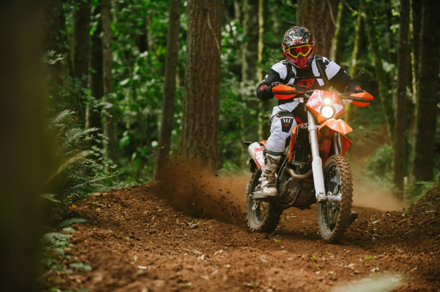 A person riding a dirt bike on top of a trail.