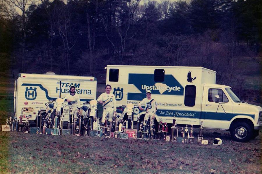 A group of people sitting in front of some trucks.